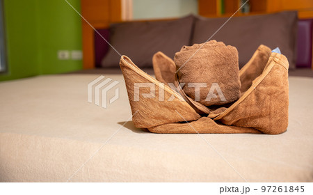 Yellow towel on bed decoration in bedroom interior, Freshly laundered fluffy towels, Towel in hotel room, Beautifully folded toiletries 97261845