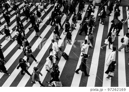 師走の大阪の街。横断歩道を渡る人々が足早に通り過ぎる。モノクロで撮影 97262169