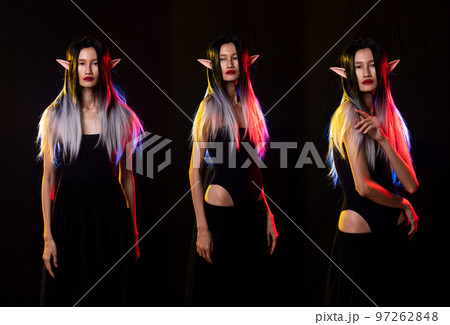 Fairy woman elf queen in black fantasy rope long dress cast spell flowing around witch. Princess girl sharp ears with beautiful face. old style cave. Spell dark magic over black background isolated Fairy woman elf queen in black fantasy rope long dress cast spell flowing around witch. Princess girl sharp ears with beautiful face. old style cave. Spell dark magic over black background isolated 97262848