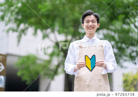初心者マークを持つエプロン姿の男性 初心者マークを持つエプロン姿の男性 97263738
