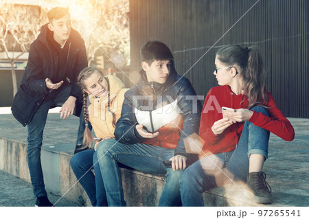 Teenagers hanging out on streets of city 97265541