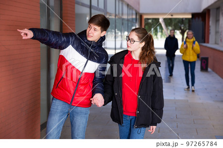 Teen boy pointing at something to girlfriend 97265784