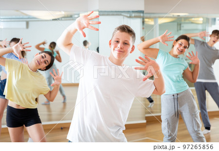 Teenage boy exercising during group dance class 97265856