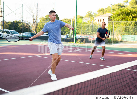 Teenage boy in sportswear playing tennis match Teenage boy in sportswear playing tennis match 97266045