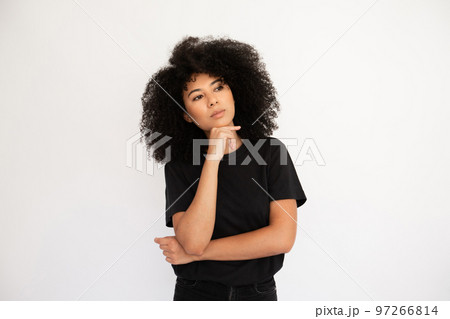 Pensive young woman looking away holding thumb on her chin Pensive young woman looking away holding thumb on her chin 97266814