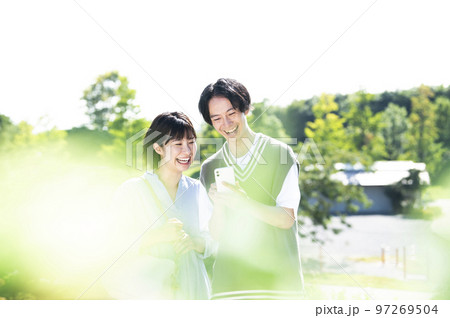 スマホで検索する若い夫婦 97269504