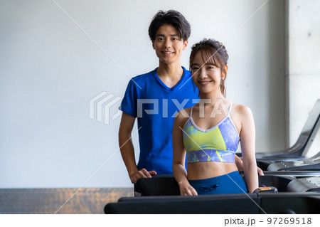 スポーツジムでトレーニングする若い男女 97269518