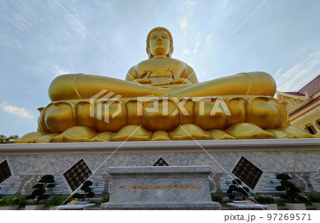 Front view Golden big Buddha statue in Wat Pak Nam Phasi Charoen, Sunlight sky and cloud background 97269571