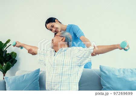 Contented senior patient doing physical therapy with the help of his caregiver. Contented senior patient doing physical therapy with the help of his caregiver. 97269699