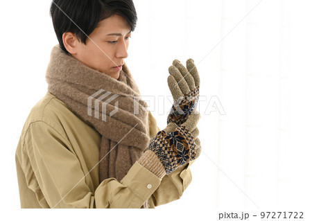 マフラーと手袋をする若い男性 97271722