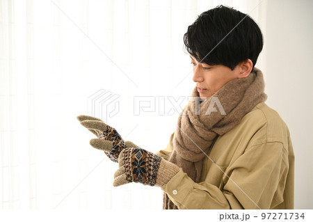 マフラーと手袋をする若い男性 97271734