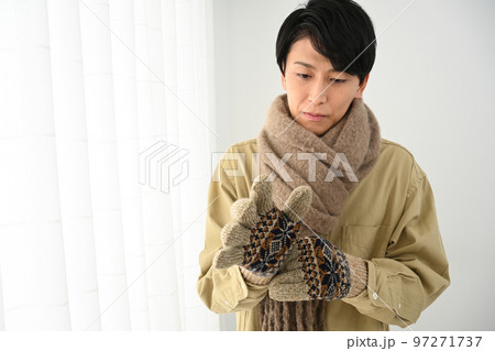 マフラーと手袋をする若い男性 97271737