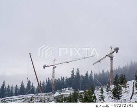 construction cranes among the mountains 97272848