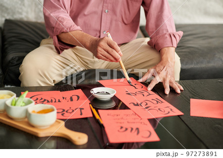 Cropped image of senior man creating red greeting cards for Chinese New Year 97273891