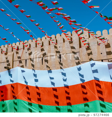 Oman national flag during Independence Day. Traditional medieval architecture in Nizwa, Oman.  97274466