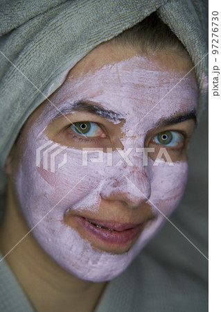 Woman with a towel over your head with face mask of therapeutic clay. 97276730