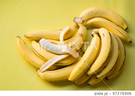 bunch of bananas - banana peel on yellow background, ripe banana peel fruit on floor 97276906