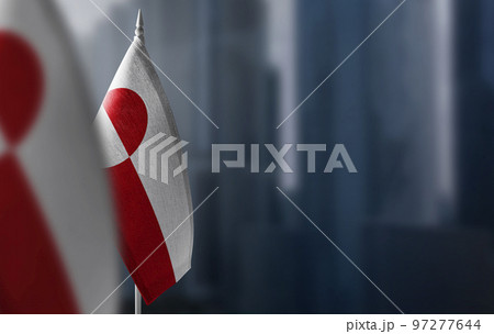 Small flags of Greenland on a blurry background of the city 97277644
