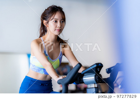 スポーツジムでトレーニングする若い女性 スポーツジムでトレーニングする若い女性 97277829