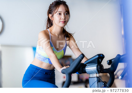 スポーツジムでトレーニングする若い女性 97277830