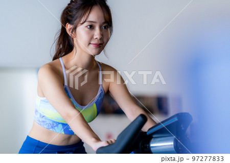 スポーツジムでトレーニングする若い女性 97277833