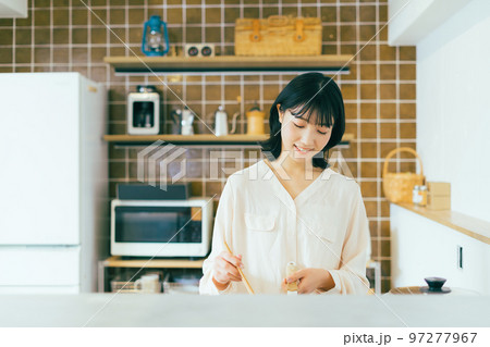 キッチンで料理する女性 97277967