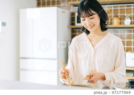 キッチンで料理する女性 97277969