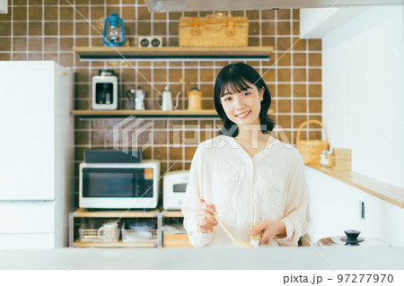 キッチンで料理する女性 97277970