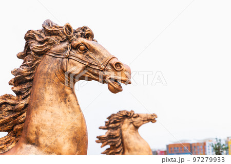 Bronze horse muzzle sculpture with flying mane on city street, close-up 97279933