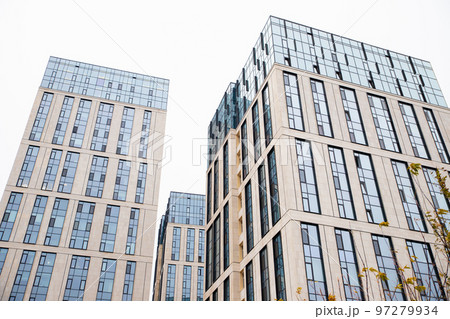 Blue beige modern apartment building. Tile and glass facade. View from street, view from below 97279934