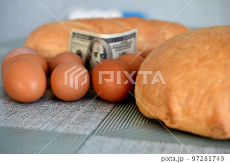 Eggs, bread and banknotes are on the kitchen table. Eggs, bread and banknotes are on the kitchen table. 97281749