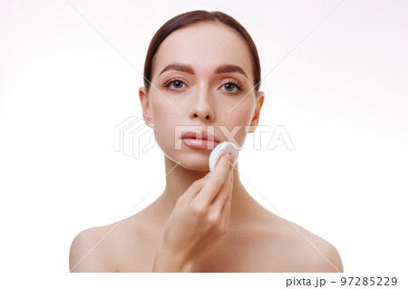 Beautiful brunette removes makeup from her face. Beautiful brunette removes makeup from her face. 97285229