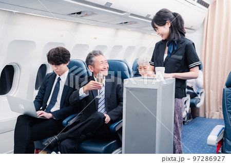 機内で飲み物を提供するキャビンクルー 機内で飲み物を提供するキャビンクルー 97286927