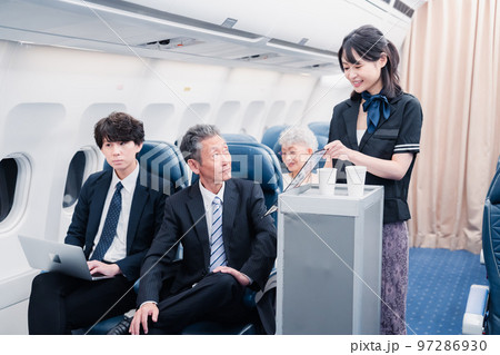 機内で飲み物を提供するキャビンクルー 97286930