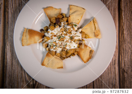 Oriental recipe aubergine and chickpea fatteh, pita, Greek yogurt, roasted pine nuts, zaatar Oriental recipe aubergine and chickpea fatteh, pita, Greek yogurt, roasted pine nuts, zaatar 97287632