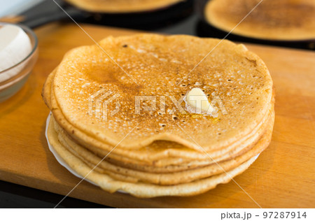 hot golden pancakes made of grain flour in the kitchen on a plate hot golden pancakes made of grain flour in the kitchen on a plate 97287914