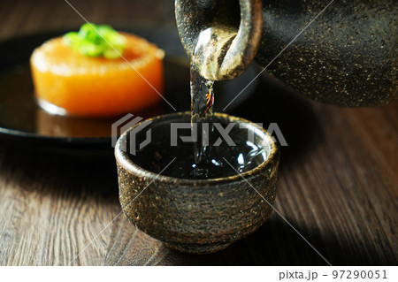 注がれる日本酒と大根の煮込み 97290051