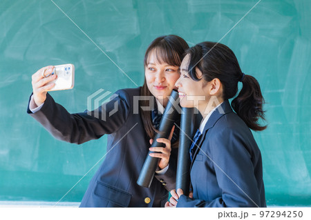 卒業証書を持って教室で記念撮影する高校生 97294250