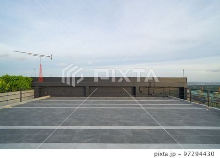 Sky garden on private rooftop of condominium or hotel, high rise architecture building with tree, grass field, and sunset sky. 97294430