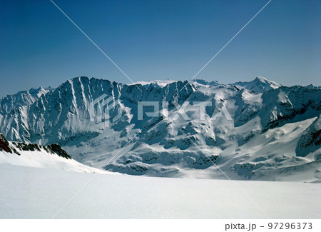 Panorama of snowy mountains and high alpine peaks in wintery Bernese Oberland in Switzerland 97296373