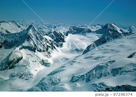 Panorama of snowy mountains and high alpine peaks in wintery Bernese Oberland in Switzerland Panorama of snowy mountains and high alpine peaks in wintery Bernese Oberland in Switzerland 97296374