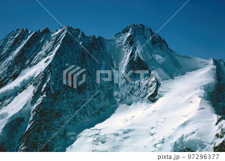 Panorama of snowy mountains and high alpine peaks in wintery Bernese Oberland in Switzerland Panorama of snowy mountains and high alpine peaks in wintery Bernese Oberland in Switzerland 97296377