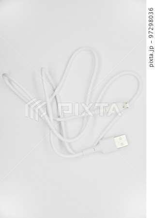 White USB cable for charging the phone on a white background. White cord for charging gadgets. White USB cable for charging the phone on a white background. White cord for charging gadgets. 97298036