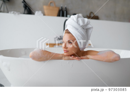 Portrait of gorgeous woman in towel on head taking bath 97303085