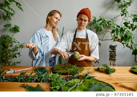 Florist and decorator team working at DIY florarium studio Florist and decorator team working at DIY florarium studio 97303165