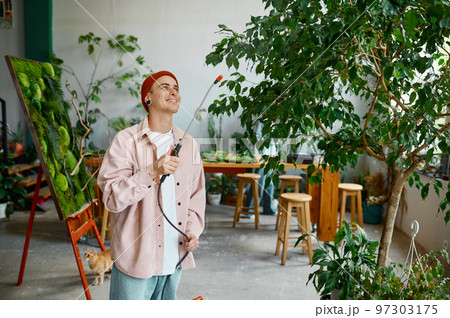 Man florist watering plants leaves 97303175