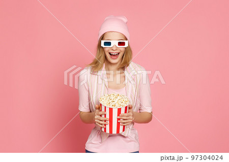 pretty blonde girl holding bucket of popcorn 97304024