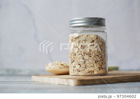 oats flakes in a jar with spoon on table  97304602