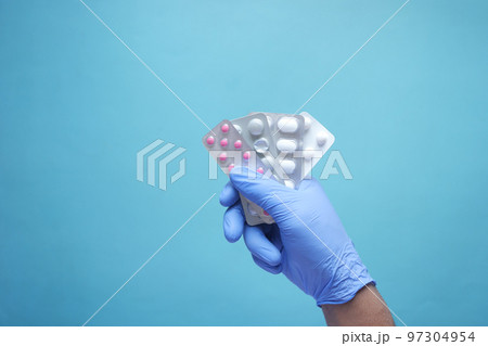 top view of hand in latex gloves holding blister pack top view of hand in latex gloves holding blister pack 97304954