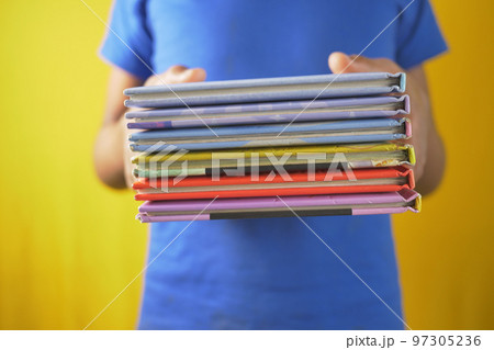 hand holding stack of books on color background  97305236
